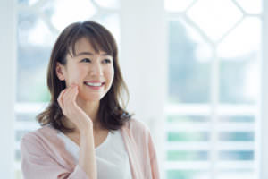 頬に手を当て微笑む女性